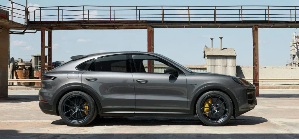 Orange Porsche Cayenne Coupe with black wheels parked in a warehouse in Boulder, Colorado